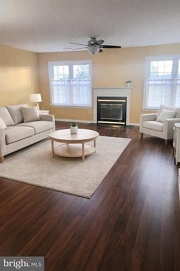Large family room with laminate floors, wood-burning fireplace and ceiling fan