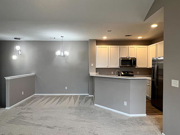 Dining area and fully updated kitchen, featuring new flooring, new quartz counters and sink, brand new appliances, and freshly painted cabinets.