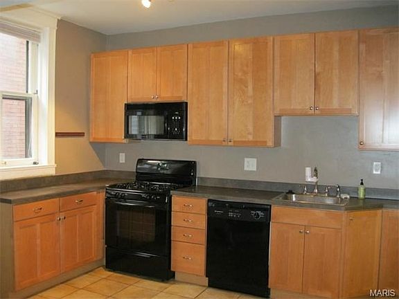 Updated kitchen with custom cabinets, ceramic floor, rear entry, and breakfast area.