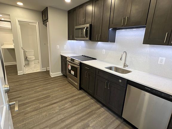 Kitchen has plenty of cabinet space with stainless steel appliances and stone countertops.