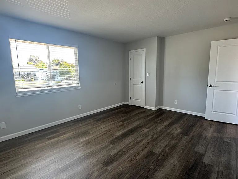 Bedroom #1 has new plank flooring, large window including window blinds for bright, natural light and a spacious walk-in closet