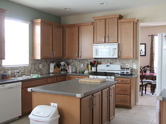 spacious island kitchen with wine rack above refrigerator