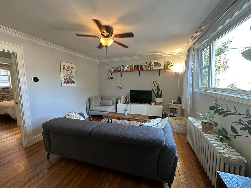 living room from front door. 2 rows of floating shelves included on back wall