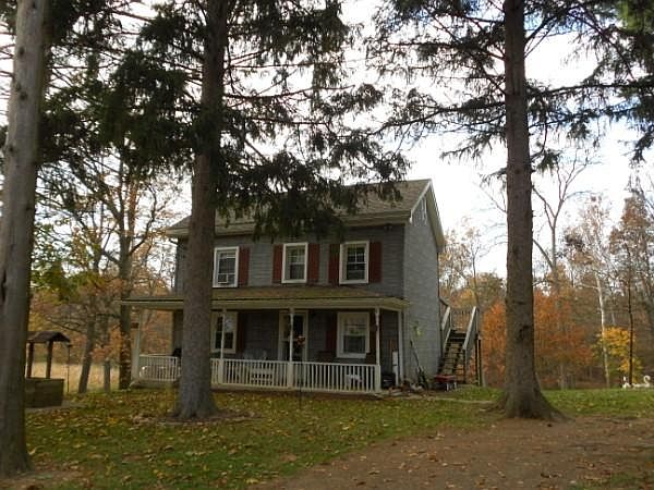 Oakdale Log Cottage with its shady front yard has a rear facing deck off the second floor.