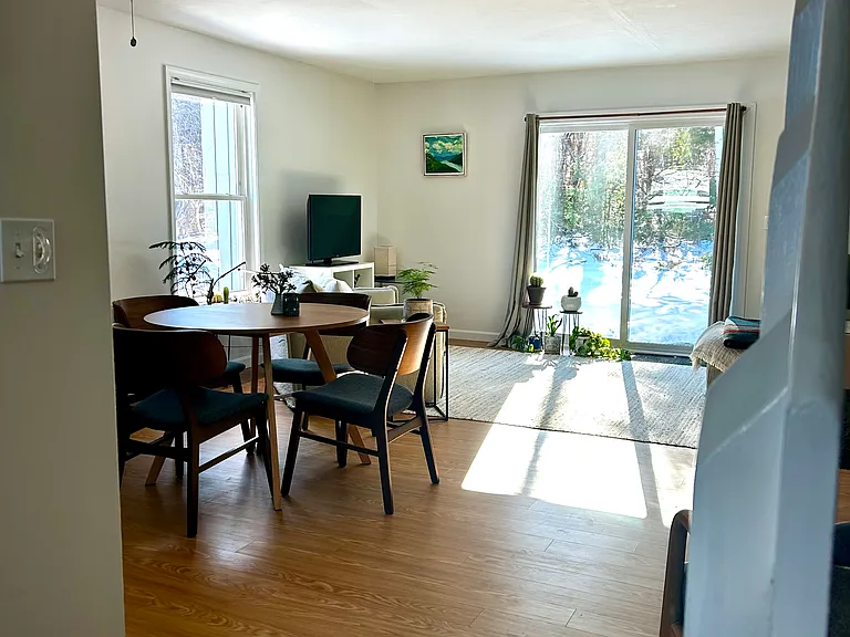 Living room as seen walking into house, kitchen on the left, stairs, closet, and bathroom on the right