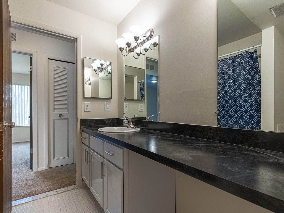 Modern bathroom with double vanity mirrors at Drawbridge Apartments East in Harrison Township, MI