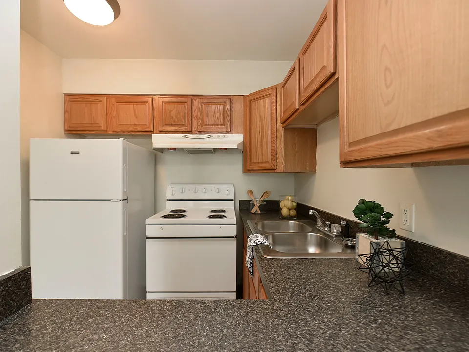 Fully equipped kitchen with white appliances & generous counter space + cabinetry