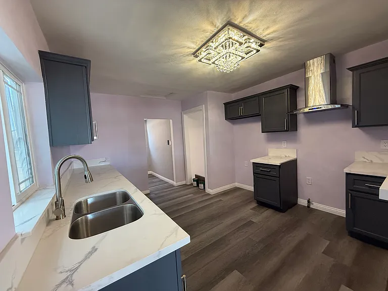 Kitchen. New countertops, new range hood, new lighting fixture, new sink. Freshly painted walls and cabinets.