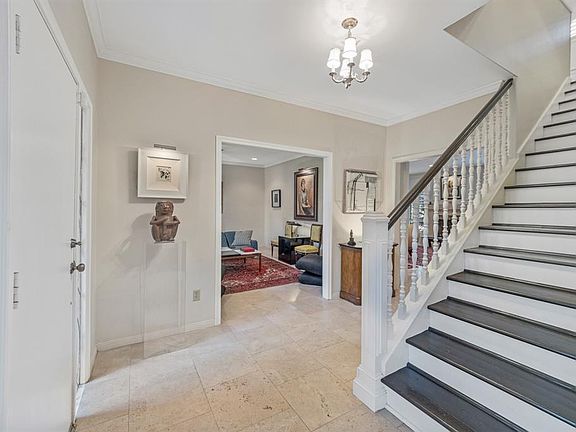 Beautiful entry with travertine tile, leaded glass windows, and chandelier.