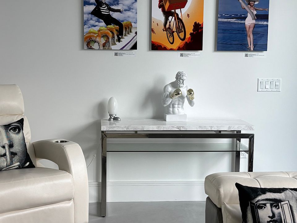 On the opposite side of the living room, a leather recliner offers the ultimate comfort and relaxation. The carefully curated original artworks displayed throughout the space add a touch of refined taste and elegance.