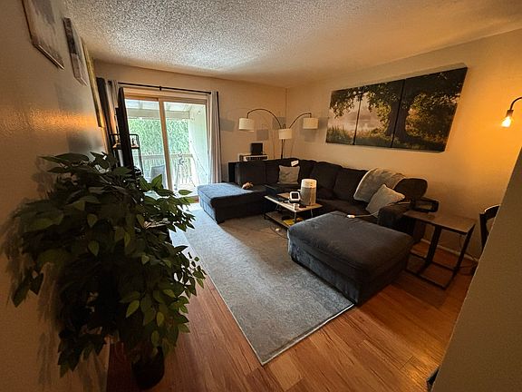Living room with plank flooring and access to balcony
