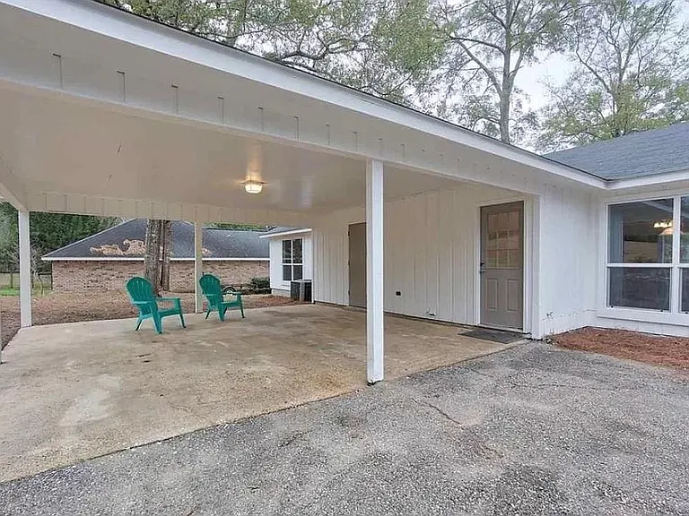 Back entry under covered carport to fit 2 vehicles with a secure large storage area