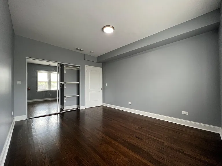 Primary bedroom with built-in organizer closet and mirrored doors. Large enough to easily accommodate a king-sized bed.