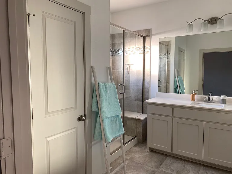 primary bathroom with separate sinks, large shower