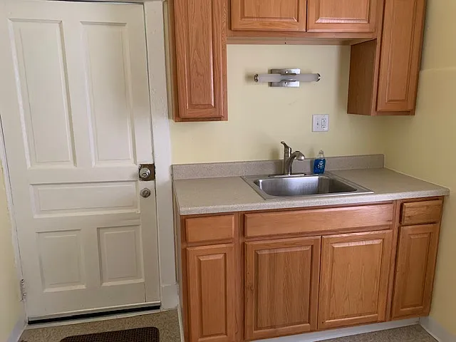 351 Williams kitchen - refrigerator and stove on opposite wall. Door to covered porch.