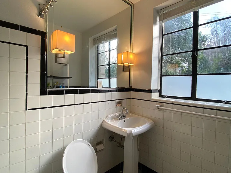 sunlit bathroom with custom tiling and enormous mirror!