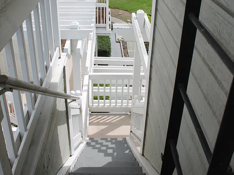 Stairs down to back patio and ladder for roof access
