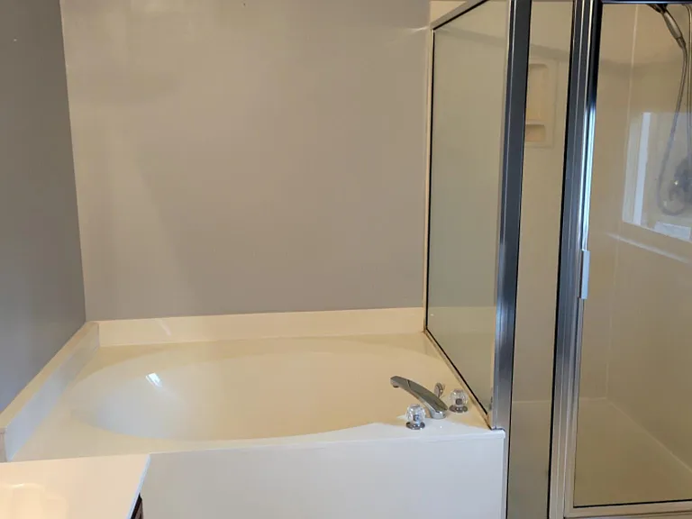 Master Bath room with tub & walk in shower and two sink cabinets