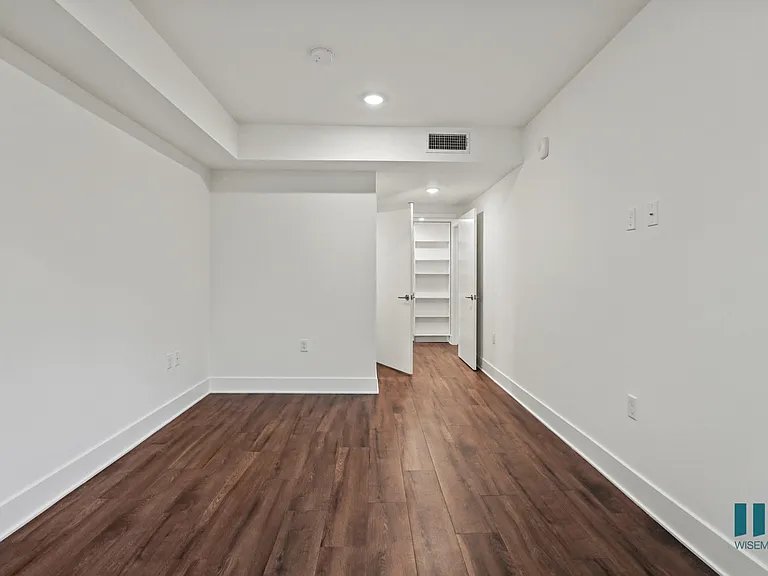 Bedroom with Walk-In Closet with Built-In Organizers, Bathroom, and Vinyl Flooring