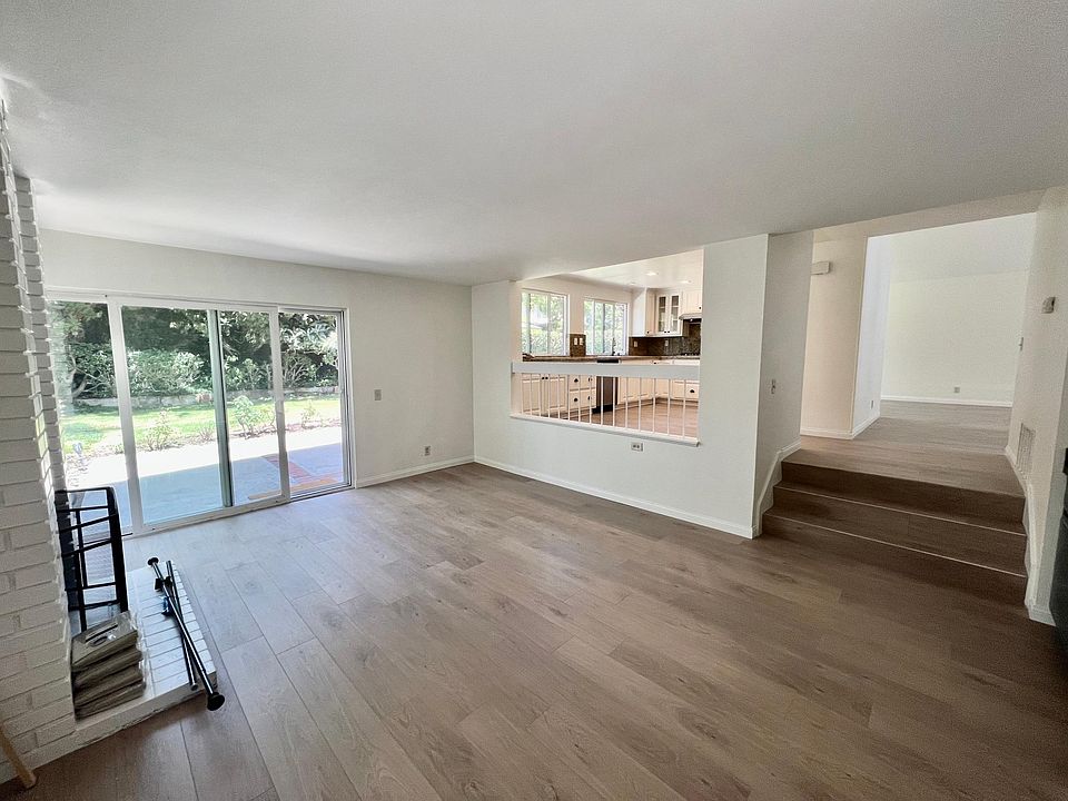looking from the step-down hearth room into the kitchen and up stairs into living room