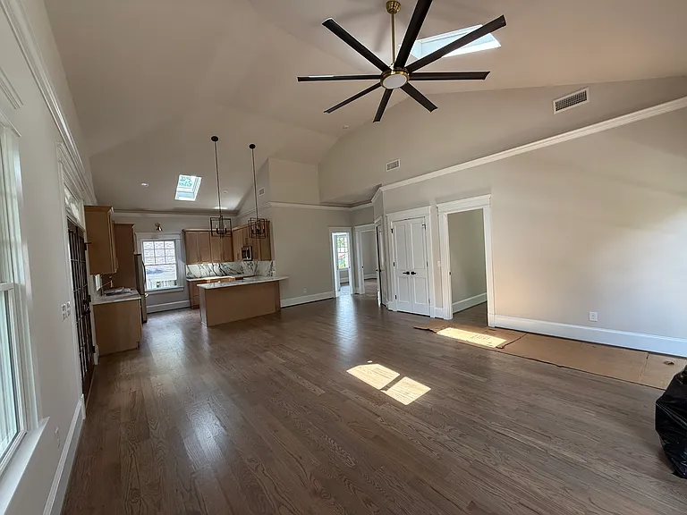 Main room looking at the kitchen. The three skylights have retracting blinds