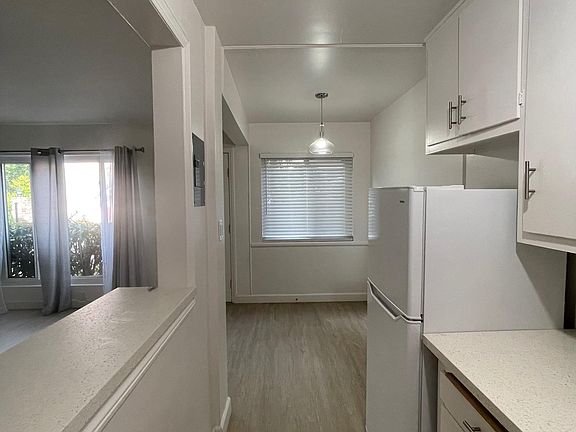 Kitchen has pass through bar, stainless range and huge sink, quartz counters, refrigerator