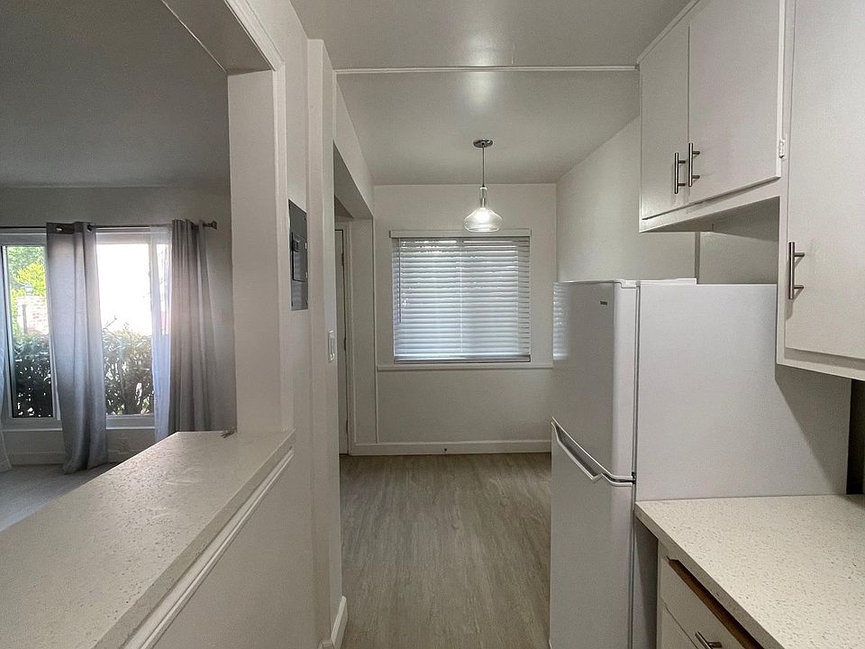 Kitchen has pass through bar, stainless range and huge sink, quartz counters, refrigerator