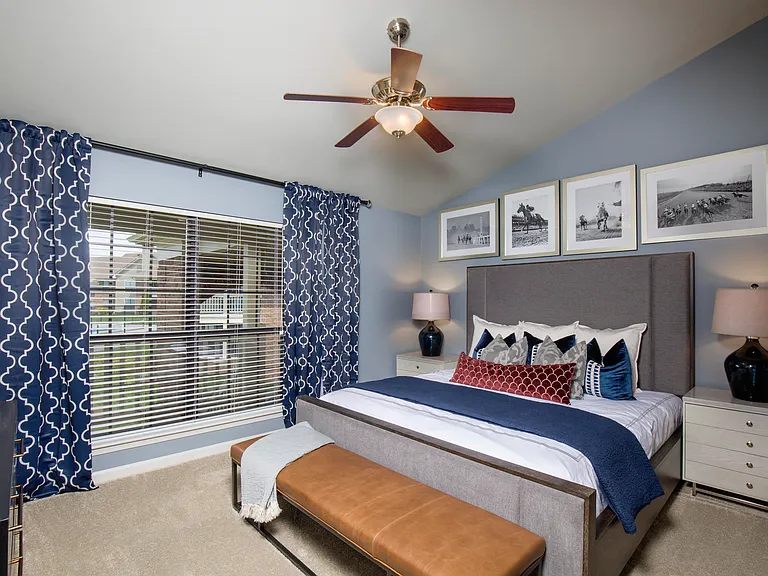 Bright bedroom with vaulted ceiling and ceiling fan