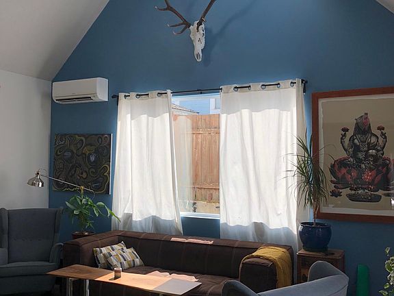 Living room/kitchen with vaulted ceiling and sky lites. 9' tall walls, huge windows and slider doors lets in tons of light.