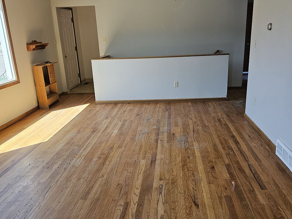 Living Room from the kitchen facing the entry and stairs to the basement. Gorgeous original hardwood floors.