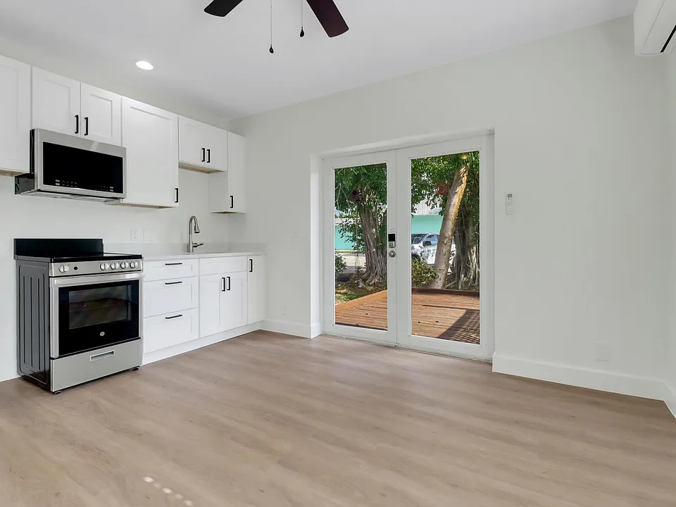 Private access thru large french doors lead into kitchen / living space - furnished and with all new appliances (furniture and refrigerator not shown).