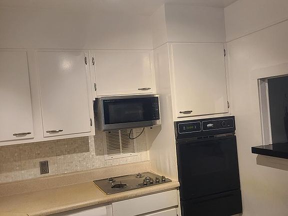 Kitchen cooking area, stove, wall oven and pan warmer, and pass-through counter