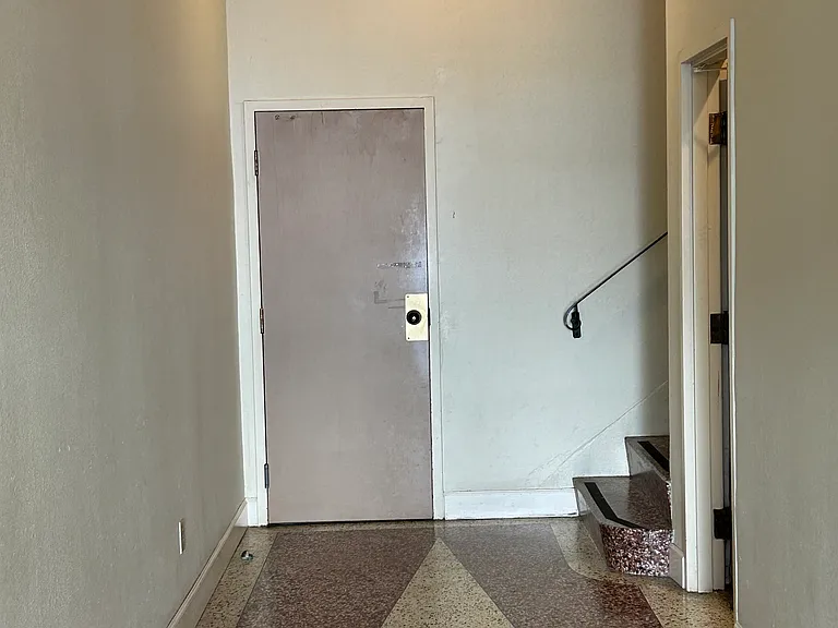 Lobby level common area entrance foyer. The door in the photo leads to the garage parking area. Door on the right leads to the laundry room.