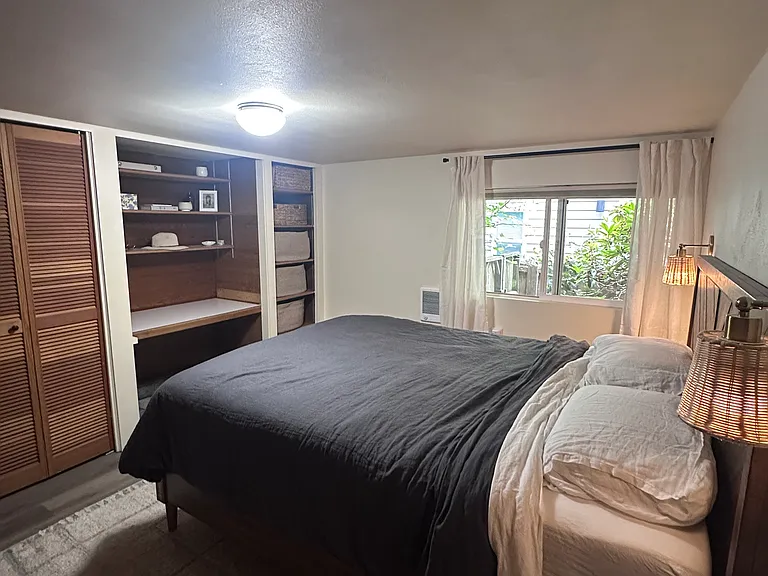 Second bedroom comfortably fits a queen-size bed and features a built-in desk, closet, and shelving. Furniture shown belongs to the current tenant and is not included.