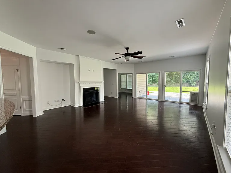 Sun-drenched living room with wall-to-wall sliding glass doors that open up directly to your massive backyard, blending indoor comfort with outdoor entertainment."