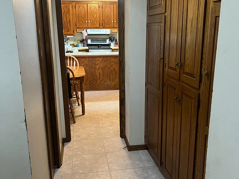 House entrance from garage. Half bath on left, main floor laundry on left, storage on the right