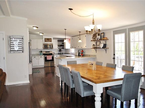 Large dining space looking into the kitchen and access to the large back deck through the French doors.