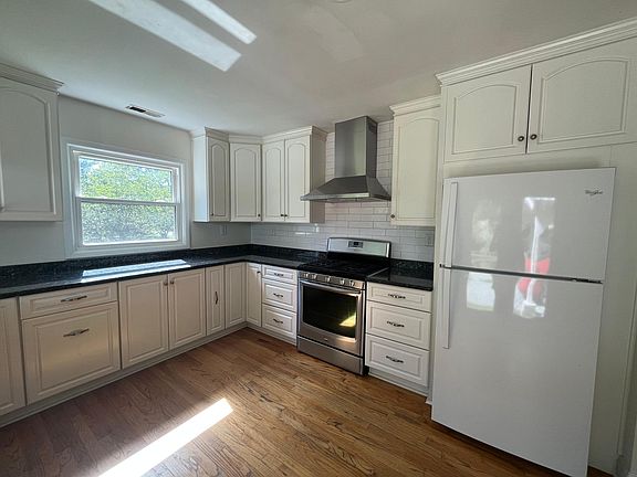 Kitchen ft. granite countertops, custom cabinetry, stainless steel range and dishwasher