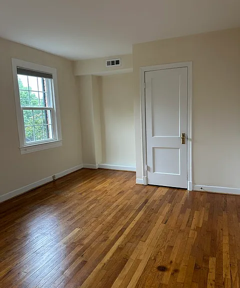 Spacious primary bedroom with hardwood floors