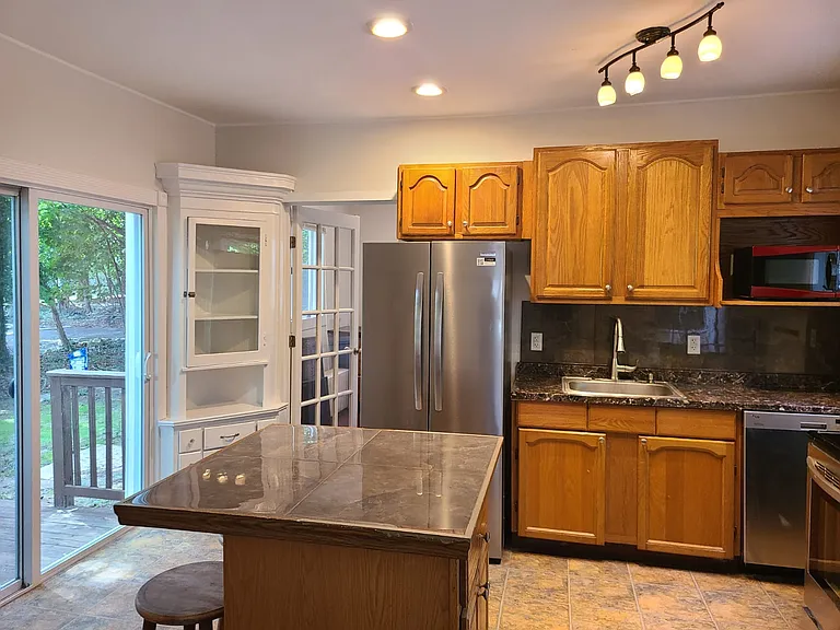 Updated kitchen with new fridge, with sliding glass doors to private deck.