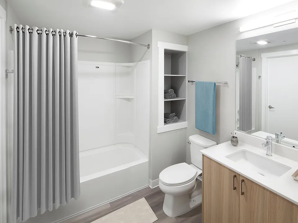 Phase II - Scheme D Bath with oak cabinetry, white quartz countertop, and hard surface flooring