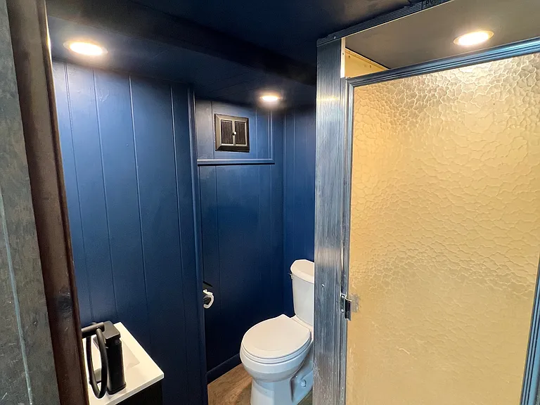 Remodeled basement bathroom with new toilet, sink, and mirror.