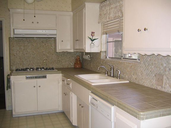 The kitchen has new light olive green tile on the counter and backspash. 