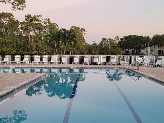 Community Pool & Hot Tub _ Enjoy a resort-style heated pool and relaxing hot tub, surrounded by lush tropical landscaping and ample lounge seating. The spacious sun deck offers plenty of room for sunbathing, reading, or unwinding under shaded umbrellas.