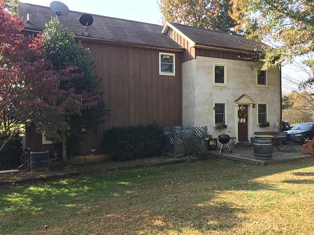 back of house, north and west facing walls of log cabin stucco to preserve logs