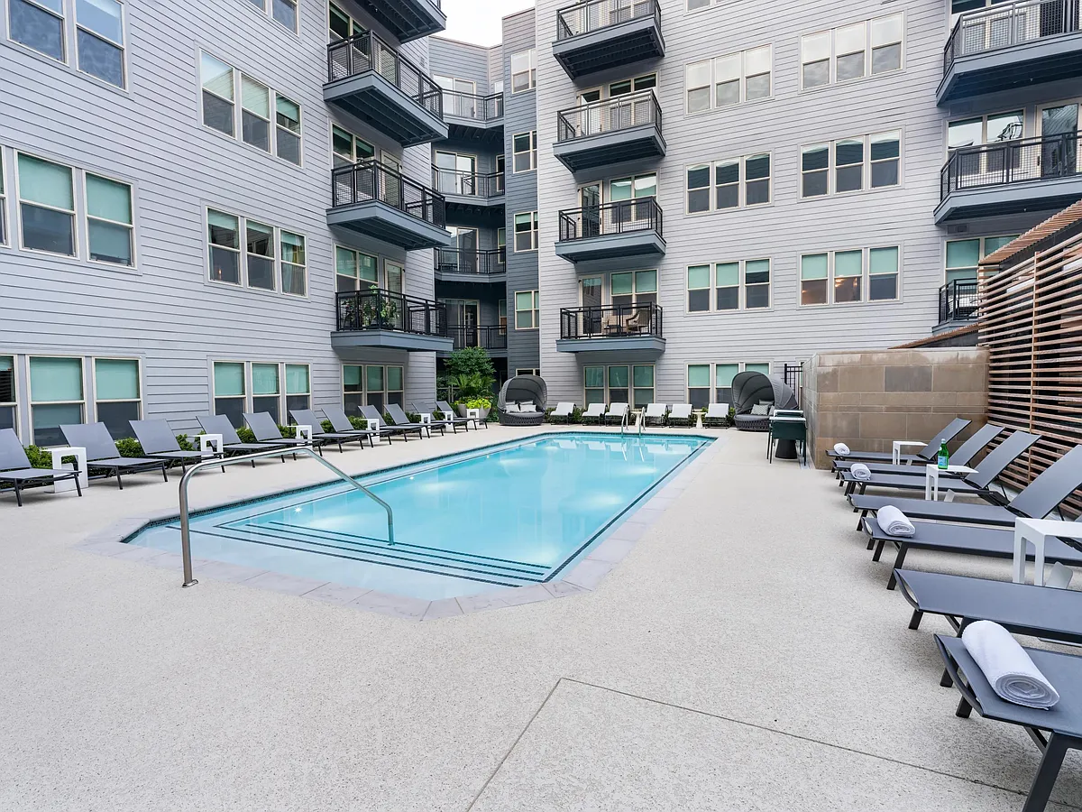 Relax by the sparkling courtyard pool_perfect for a refreshing dip or unwinding in a private lounge chair. - Modera Falls Church