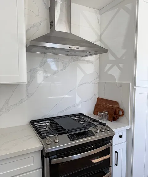 gorgeous!! stainless hood, gas range and beautiful new quartz