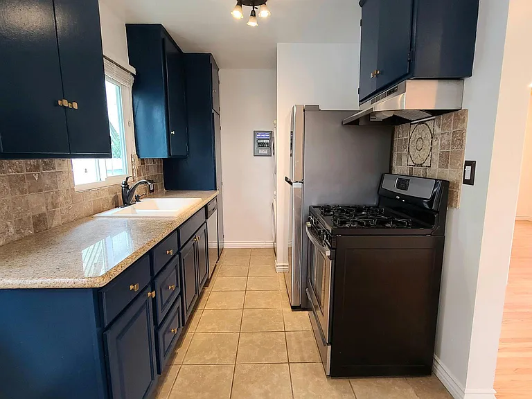 Kitchen has travertine tile, granite counters and ceramic tile floor.