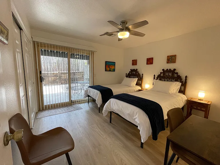 Secondary Bedroom in 2 twin XL configuration and view of downstairs patio dining space.