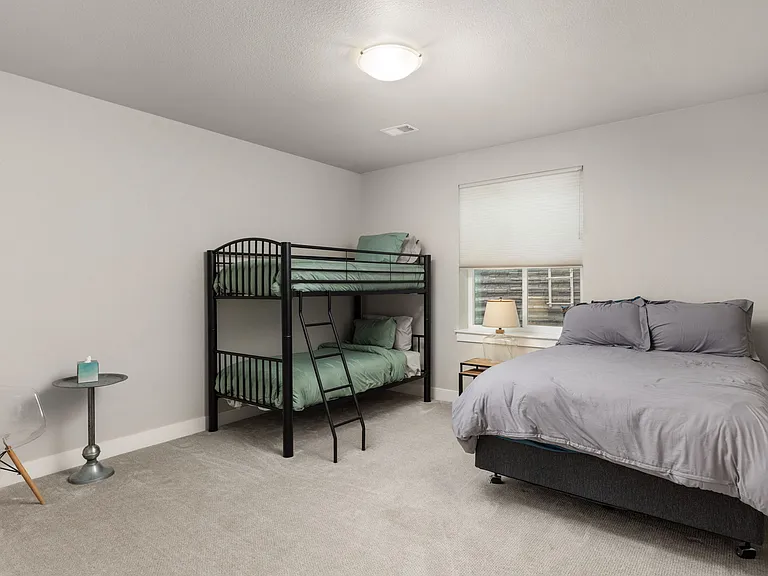 Lower level bedroom (furniture pictured is for staging purposes only - unfurnished unit)